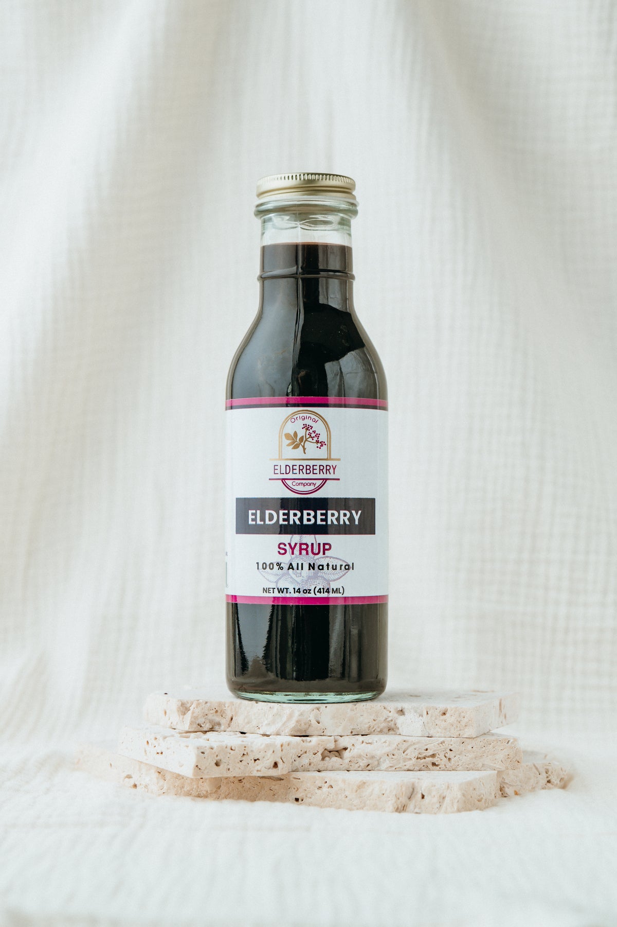 Bottle of elderberry syrup on a white textured background