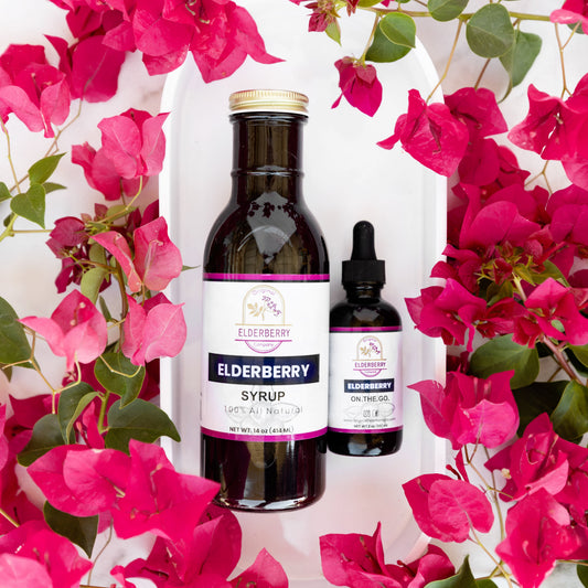 Elderberry syrup in a glass jar next to a small bottle of elderberry tincture with fresh elderberries and honey on a wooden table, comparing immune support options for families.