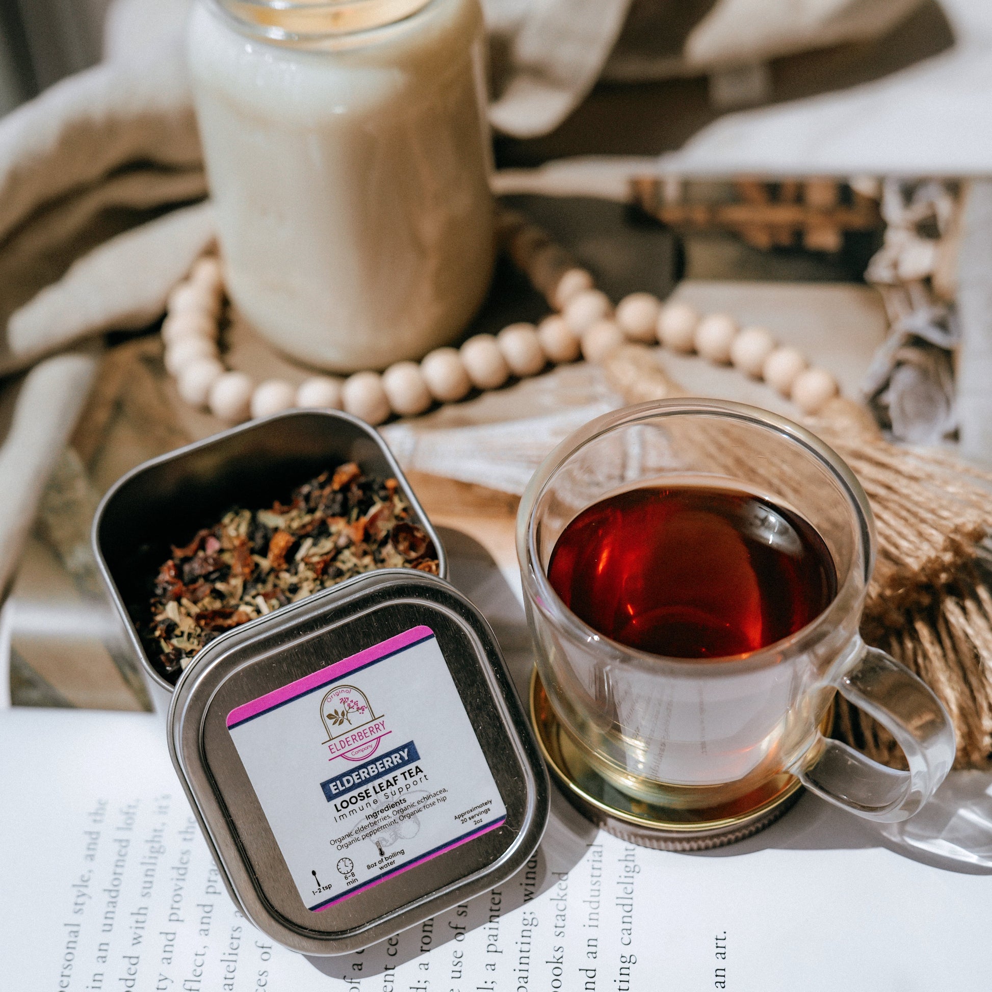 Tea packaging with a cup of tea and a candle on a surface